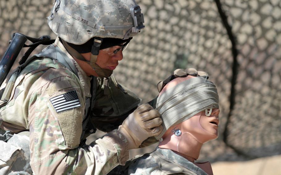 Pfc. Kyle Ishikawa, infantryman, Company A, 2nd Battalion, 23rd Infantry Regiment, 1st Stryker Brigade Combat Team, 4th Infantry Division, practices first aid on an open head wound during Expert Infantryman Badge evaluations on March 15, 2016. The Army is planning to revamp evaluations for the badge.