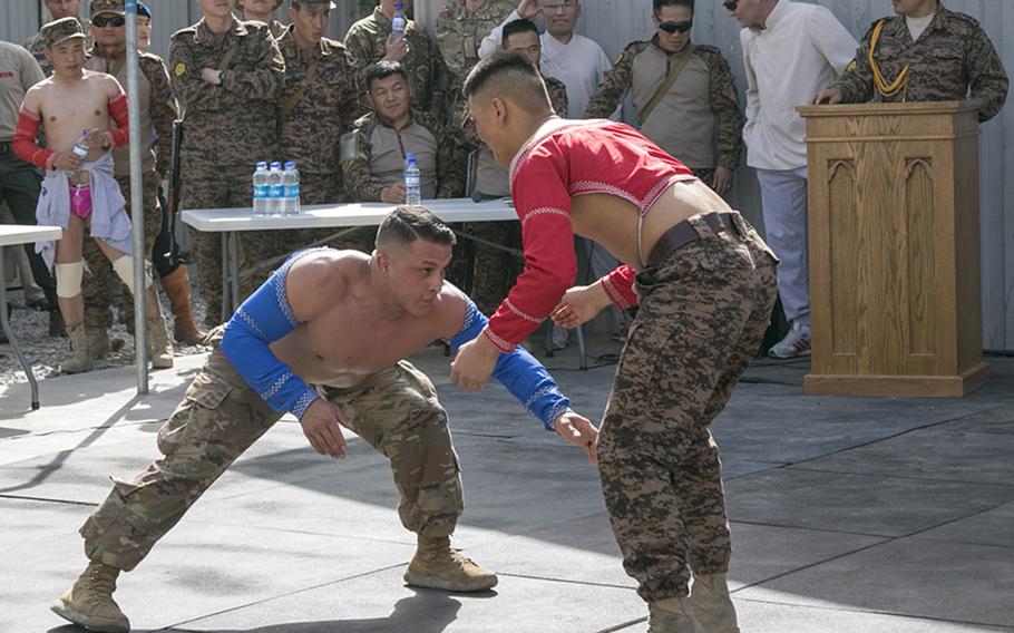 Spc. Michael Pereyra, left, 24, of the 1st Squadron, 180th Cavalry Regiment from Oklahoma City, Okla., faces off against an opponent in Mongolian-style wrestling at New Kabul Compound in Kabul, Afghanistan, July 12, 2018, as part of a festival celebrating the Mongolian revolution.