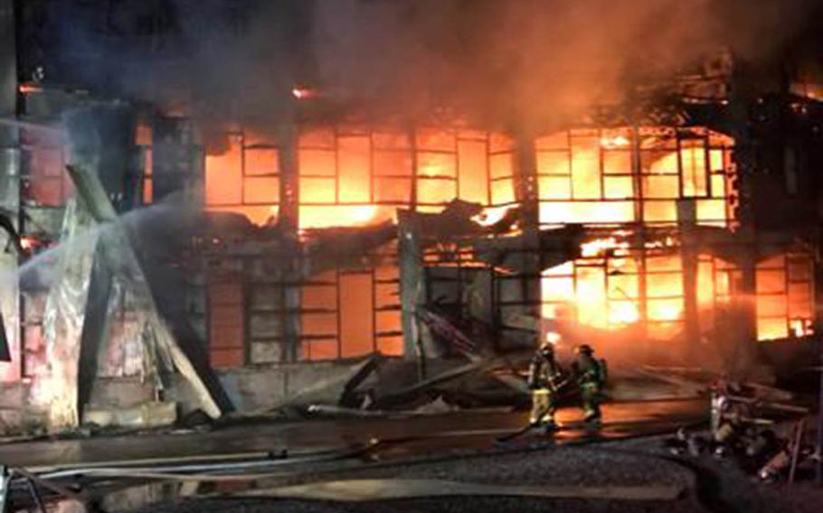 Emergency personnel from Yokosuka Naval Base, Japan, help fight a fire at an off-base warehouse, Sunday, July 22, 2018.
