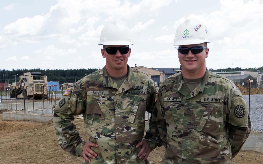 Sgt. 1st Class Andrew Sovey, left, and his brother, Staff Sgt. Stephen Sovey, engineers from Michigan's Upper Peninsula, in front of one of their work sites at Drawsko Pomorskie, Poland, where they are constructing tank range facilities, Wednesday, July 26, 2018.