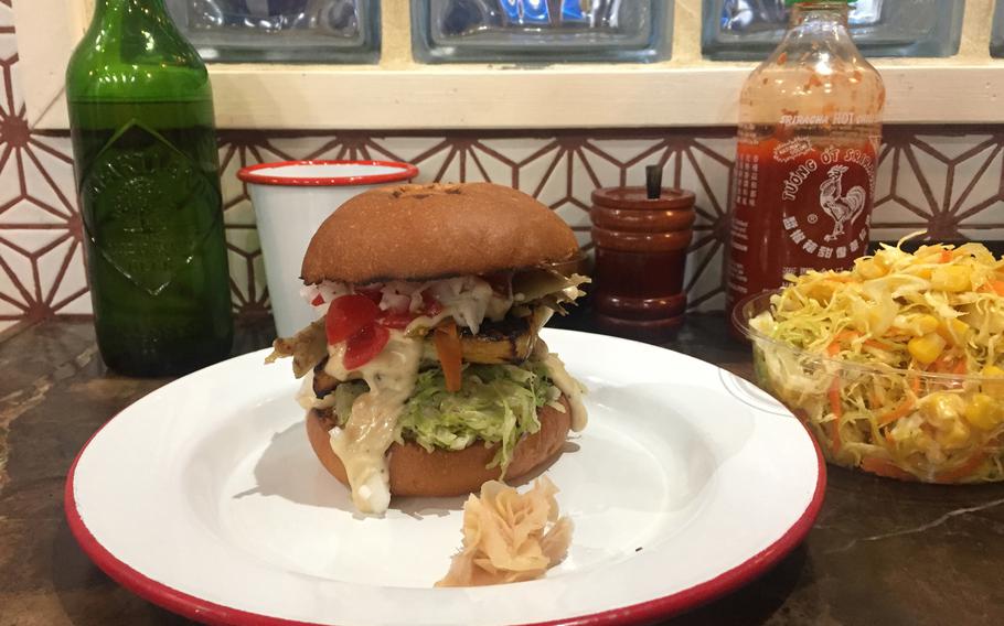 Delifucious' Saikyo Grilled Fish Burger (1,200 yen) is served with cheese sauce and a medley of fresh vegetables. The fish is prepared using "saikyo" — a curing technique unique to Kyoto cuisine. 