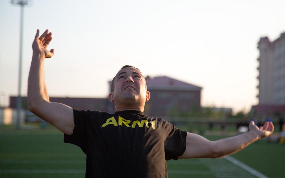 A soldier from the 1st Armored Combat Brigade, 3rd Infantry Division tosses a medicine ball over his head during a demo of the new Army Combat Fitness Test at Camp Humphreys, South Korea, Tuesday, July 31, 2018.
