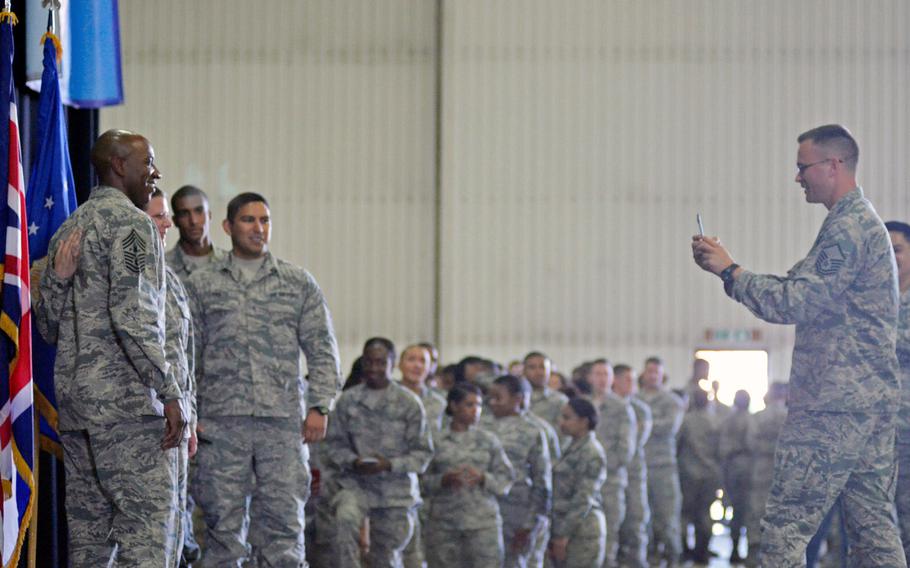Airmen line the wall of a hangar for photographs with Chief Master Sergeant of the Air Force Chief Kaleth O. Wright, after a townhall at RAF Lakenheath, England, Wednesday, August 1, 2018. 
                