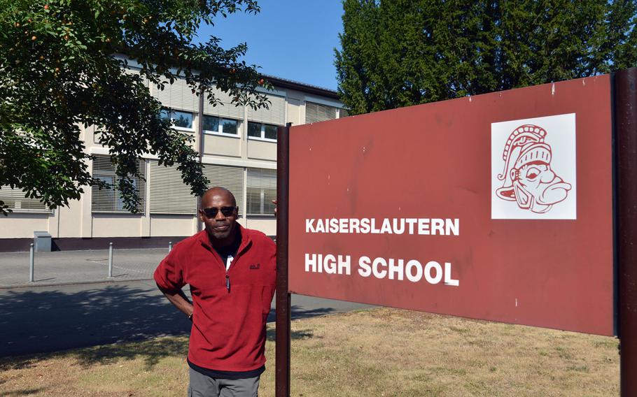 Kaiserslautern High School principal Barriett Smith stands next to the old school sign with its Raider mascot. When the school wanted to make minor changes to the Raider, the complaints from alumni were loud, Smith said. The Raider remained unchanged. Smith graduated from KHS in 1976.