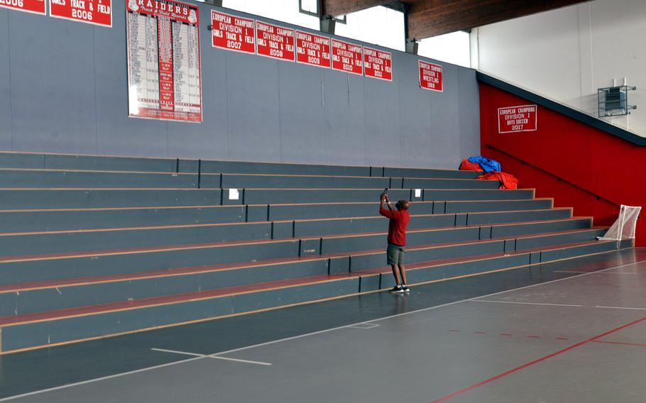 Kaiserslautern High School principal Barriett Smith takes a photo of Raiders track and field records that hang in the old KHS gym. The sign and the championship banners will hang in the new high school gym. Smith is a KHS alumnus, graduating in 1976.