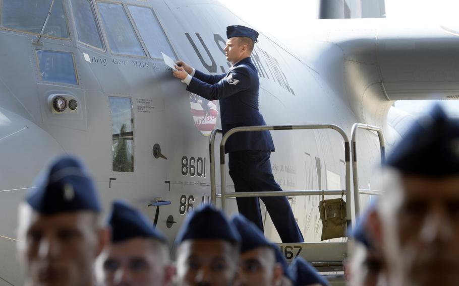 Staff Sgt. Mark Waldschmidt reveals Brig. Gen. Mark R. August's name on a C-130J after August took command of the 86th Airlift Wing during the wing change-of-command ceremony at Ramstein Air Base, Germany, Thursday, Aug. 9, 2018. August took over command from Brig. Gen. Richard G. Moore Jr.