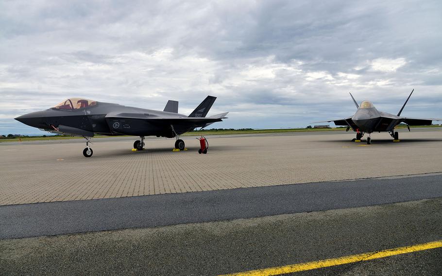A Norwegian F-35 and a U.S. Air Force F-22 Raptor stand on the tarmac after landing at Orland Main Air Station, Norway, Wednesday, Aug. 15, 2018.