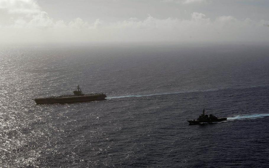The aircraft carrier USS Ronald Reagan sails alongside the Japan Maritime Self-Defense Force destroyer JS Kirishima in the Philippine Sea, Wednesday, Aug. 15, 2018.