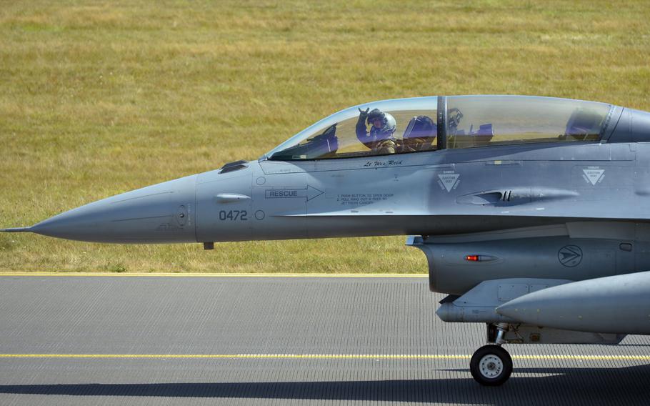 A F-16 Fighting Falcon pilot of the 480th Fighter Squadron waves to international photographers after landing at Spangdahlem Air Base, Germany, Thursday, Aug. 18, 2018. The photographers were at the base to photograph visiting F-22 Raptors.