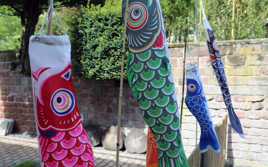 Banners colored to represent koi flutter in the wind outside the Japanese Garden in Kaserslautern, Germany.