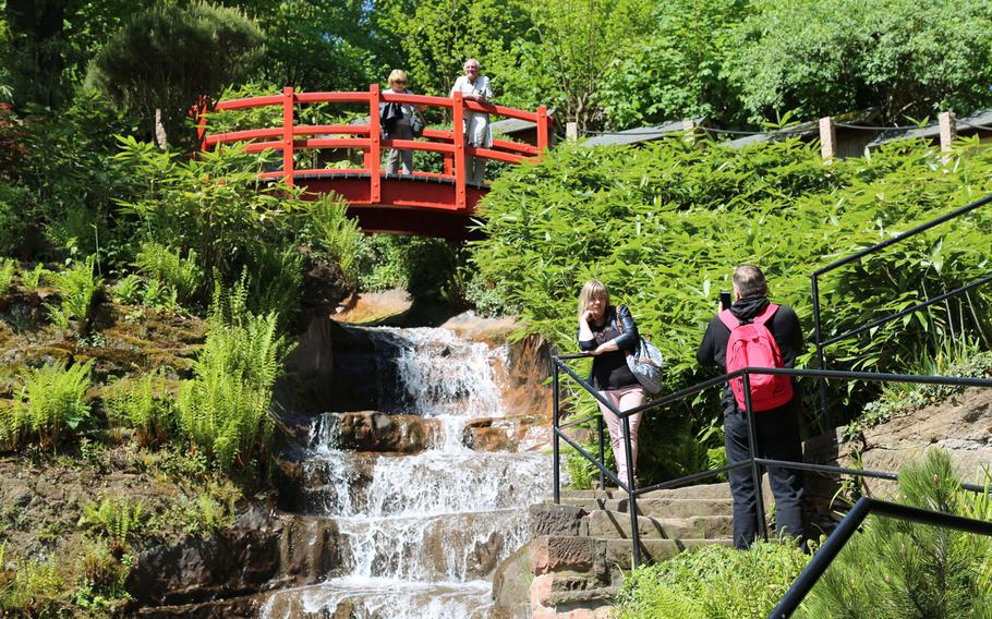 Tourists take photographs in front of a waterfall in the Japanese Garden in Kaiserslautern, Germany. Opened in 2000, the garden has become a place of peace and meditation for locals and members of the military community.