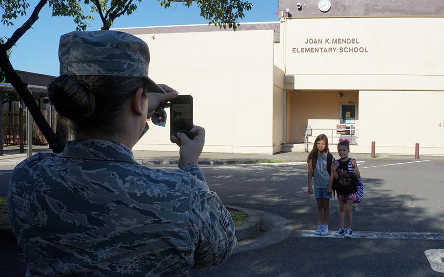 Air Force Staff Sgt. Jaimie Ropp captures a memory of her daughters, Laney and Kyndal Ropp, on the first day of school at Joan K. Mendel Elementary School at Yokota Air Base, Japan, Monday, Aug. 27, 2018.