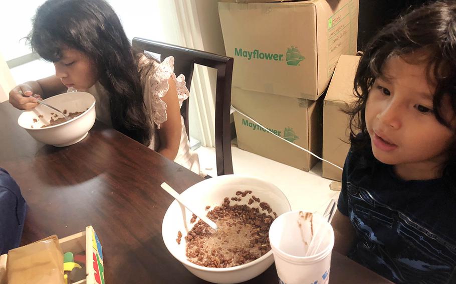 Surrounded by boxes from their father's new posting to Yokosuka Naval Base, Japan, Kyra Fowler, 9, and Richard Fowler IV, 7, eat Japanese cereal before the first day of school, Monday, Aug. 27, 2018.
