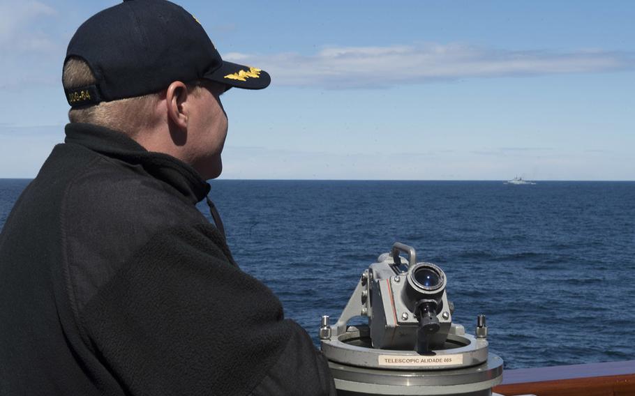 Cmdr. Peter Halvorsen, commanding officer of the guided-missile destroyer USS Carney, watches the Russian frigate RFN Boiky from the ship's bridge wing while on patrol in the Baltic Sea, May 9, 2017.