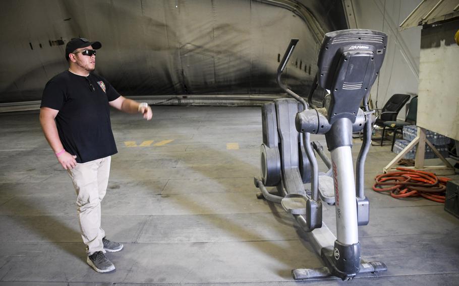 Don Baumgartner, director of Morale, Welfare and Readiness for Area Support Group-Afghanistan, examines a discarded elliptical bike found in a scrapyard at Bagram Air Field, Afghanistan. Baumgartner goes to scrapyards to find gym gear needed to serve the recent influx of troops in Afghanistan.