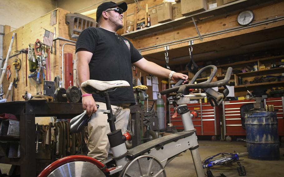 Don Baumgartner, director of Morale, Welfare and Readiness for Area Support Group-Afghanistan, picks up a spin bike he had repaired after finding parts at a scrapyard at Bagram Air Field, Afghanistan. 