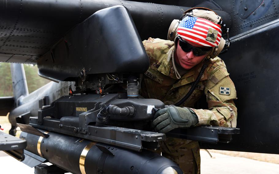 Sgt. Michael Salvi, an Apache helicopter electrician with the 6th Squadron, 17th Cavalry Regiment, 4th Infantry Division, checks the armaments of an AH-64D Apache during his squadron's first gunnery training since they arrived in Europe to support Operation Atlantic Resolve, at Grafenwoehr, Germany, Wednesday, Aug. 29, 2018.