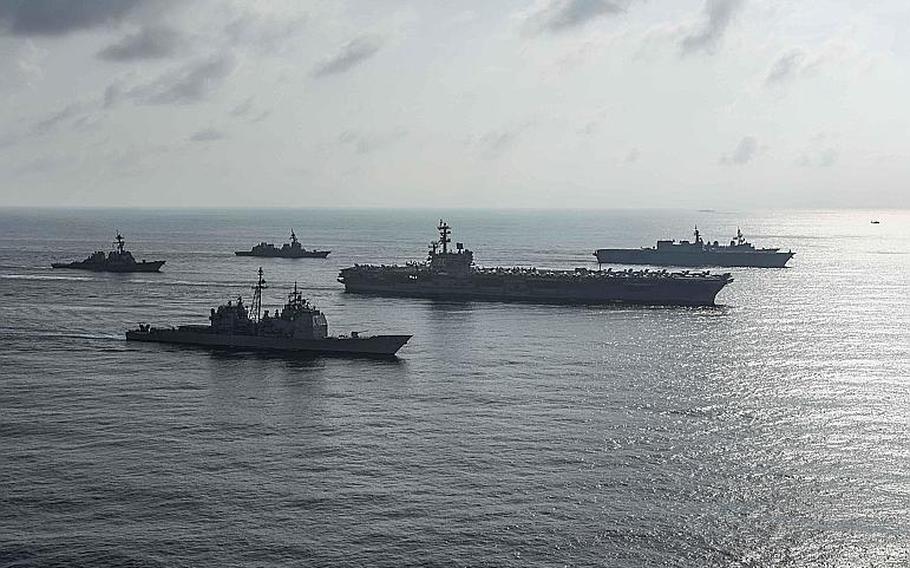 The USS Ronald Reagan, the USS Antietam and the USS Milius steam through the South China Sea with Japanese vessels, Friday, Aug. 31, 2018.