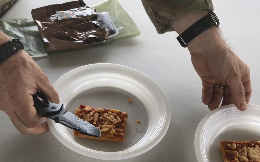 Navy Lt. Tom Perez prepares to serve two halves of a Meal, Ready to Eat pepperoni pizza during a taste test of the new military ration at NATO headquarters in Kabul, Afghanistan, on Wednesday, July 4, 2018.