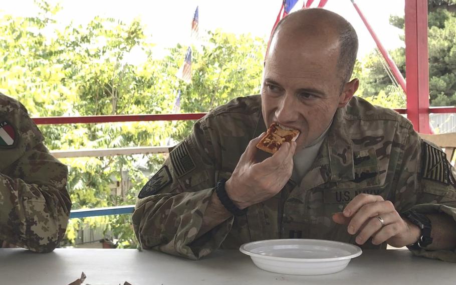 Pictured here biting into a Meal, Ready to Eat pepperoni pizza on Wednesday, July 4, 2018, is Navy Lt. Tom Perez, one of six U.S. troops to sample the new pizza ration during a taste test in Kabul.