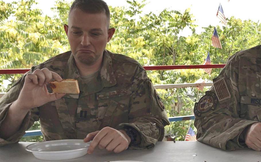 Air Force Capt. Robert Erskine inspects his half slice of a Meal, Ready to Eat pepperoni pizza during a taste test of the new military ration in Kabul, Afghanistan, on Wednesday, July 4, 2018.