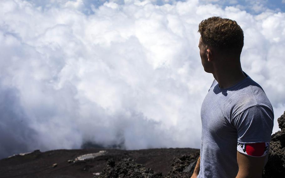 Cpl. Michael Onesty, an aviation precision measurement equipment technician with Marine Aviation Logistics Squadron 12, looks down from the summit of Mount Fuji, Aug. 2, 2018.