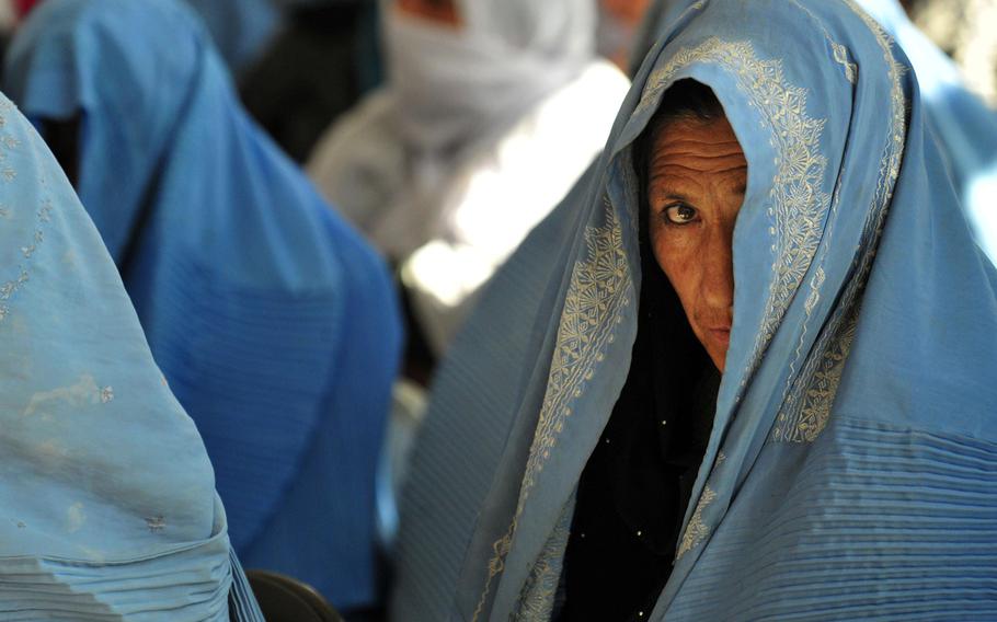 A woman peeks through her burqa to witness events at an International Women's Day celebration in Ghazni City, Afghanistan, March 8, 2011.