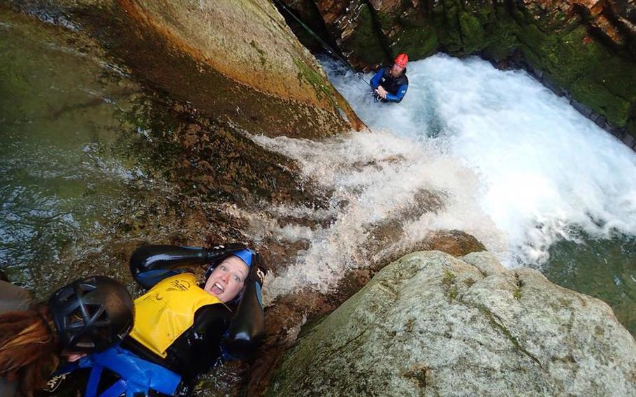 Stars and Stripes reporter Caitlin Doornbos screams before sliding backwards and head-first down a waterfall. Canyons tour guides are very experienced and teach daredevils how to take adventurous risks safely. 