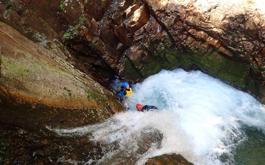 Canyoners take a break in the pool below a 20-foot waterfall. The water is deep enough to dive into head first.