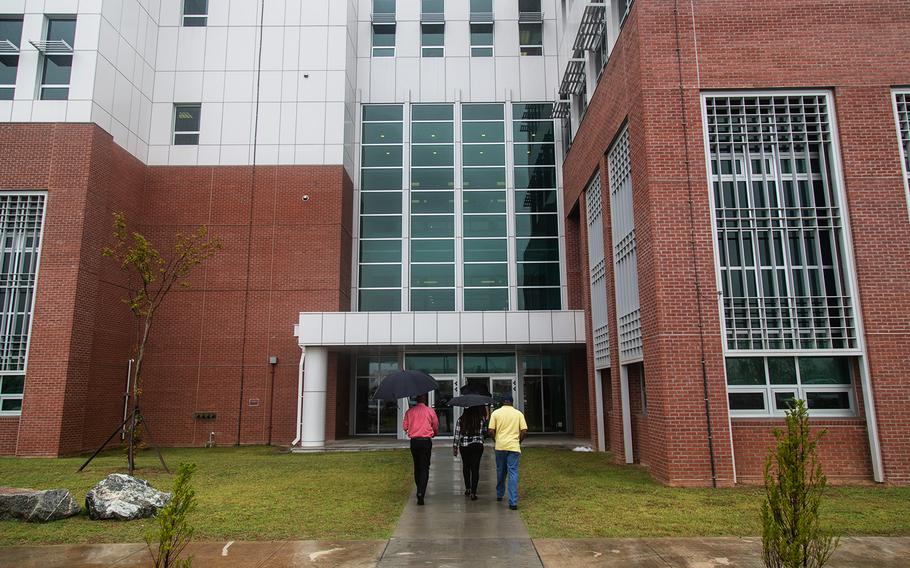 People walk toward a building that houses Stars and Stripes' new Korea headquarters at Camp Humphreys, Thursday, Sept. 20, 2018.