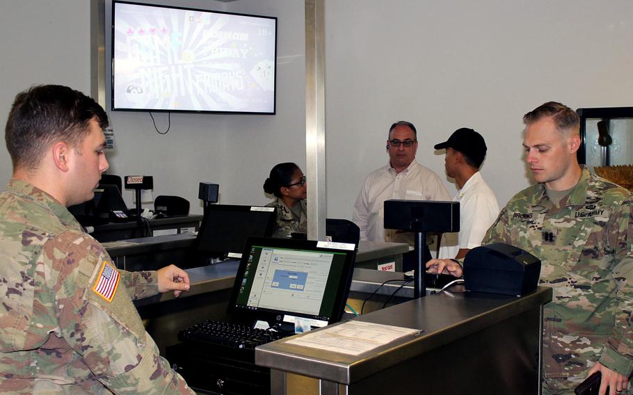 Pvt. Daniel Wilson, 212th Combat Support Hospital, accepts payment from Cpt. Timothy Brocks, 10th Army Air and Missile Defense Command, at the Defender Cafe at Rhine Ordnance Barracks, Kaiserslautern, Germany. The dining facility is one of 14 in Europe that now offer credit and debit card payment.