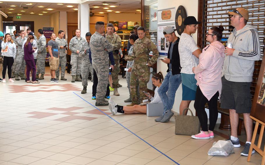 Airmen at Aviano Air Base's military clothing shop wait for the store to open so they can purchase their new Operational Camouflage Pattern uniforms, Monday, Oct. 1, 2018.