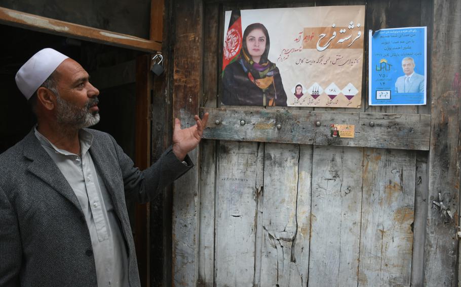 Ghulam Qadir, 60, speaks of the parliamentary candidates he supports, whose election posters adorn his carpentry shop in Kabul, on Wednesday, Oct. 10, 2018.