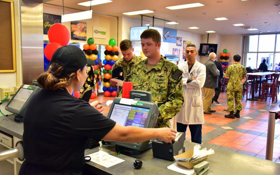 A sailor orders a meal at a new 24-hour food court near the waterfront at Yokosuka Naval Base, Japan, Monday, Oct. 22, 2018.