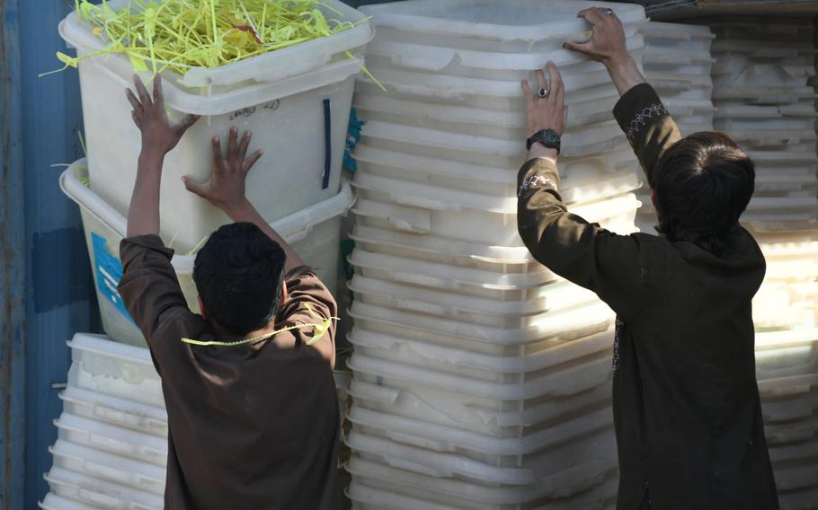 Boys at an election office in Kandahar help load trucks with ballot boxes on Friday, Oct. 26, 2018. The boxes will be dispersed at local polling centers ahead of voting on Oct. 27.