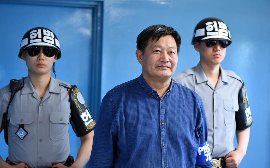 A man poses near South Korean soldiers inside a conference building at the Joint Security Area on the border of North and South Korea, May 24, 2017.