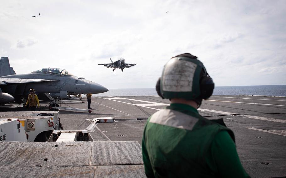 A hook-runner awaits the landing of an F-18 Super Hornet aboard the USS Ronald Reagan during Keen Sword drills at sea, Saturday, Nov. 3, 2018.