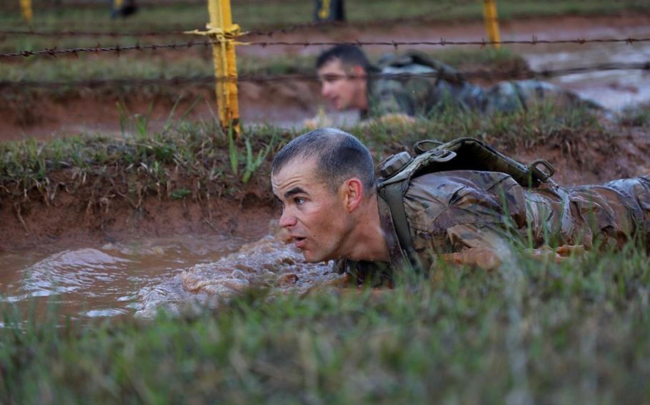 A U.S. Army Ranger low crawls under barbed wire at Malvelsti during the 35th annual David E. Grange Jr. Best Ranger Competition on Fort Benning Ga., April 13, 2018. The three-day event tests competitors' physical, mental, and technical capabilities.