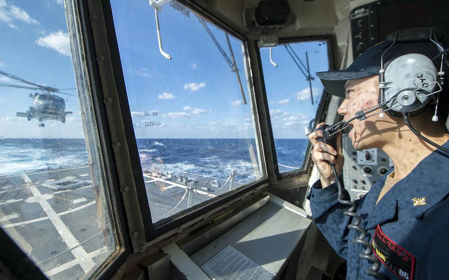 Ensign Thanh Xuong Giang relays information to the air and deck crew aboard the guided-missile destroyer USS McCampbell in the East China Sea, Dec. 27, 2018.