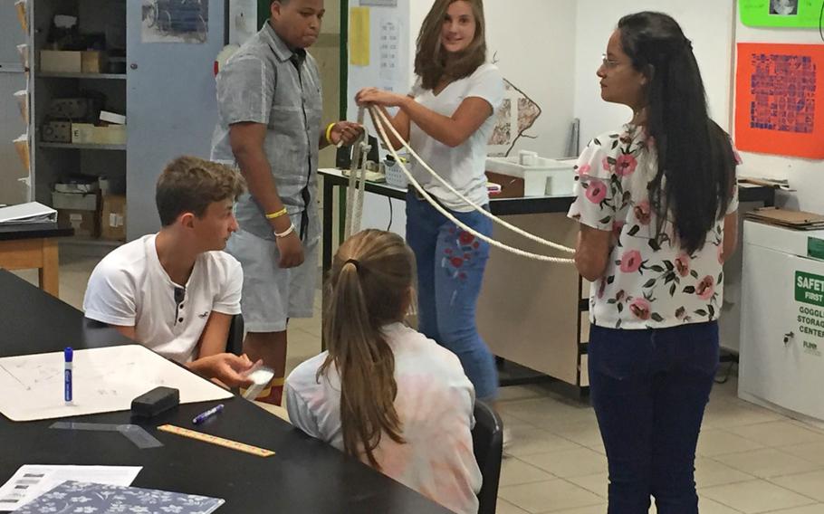 Geometry students use a rope to show how to calculate a triangle during class at Naples High School near Naples, Italy. The Department of Defense Education Activity plans to increase class sizes in its middle and high schools next year, a decision that would reduce staff by about 300.