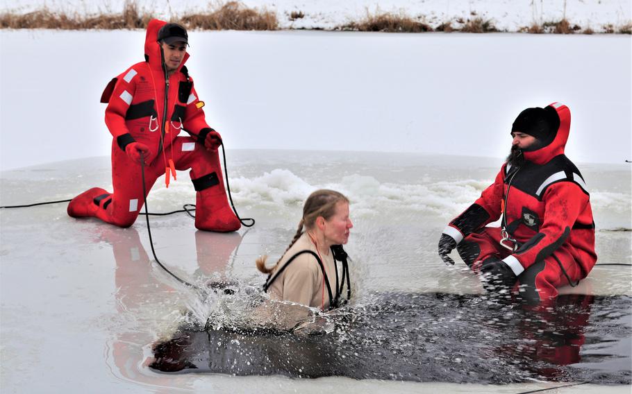 A soldier takes the plunge into a hole cut into ice-covered Big Sandy Lake as part of cold-water immersion training of the Cold-Weather Operations Course on Dec. 13, 2018, at Fort McCoy, Wis.