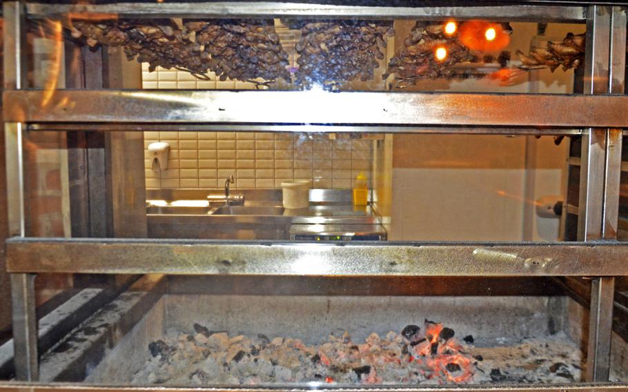 Chickens hanging over an wood-burning fire pit at BEFeD, a restaurant in Sacile, Italy, that is a local favorite place to eat flavorful chicken, hamburgers, club sandwiches and house-brewed beer.