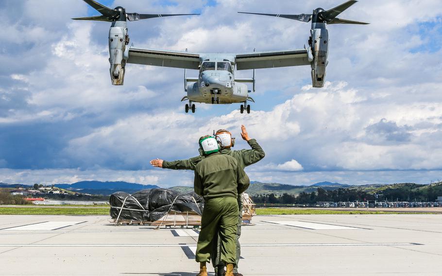 U.S. Marine Corps Sgt. Nicholas Attikai, front, 3rd Marine Aircraft Wing, directs an MV-22 Osprey while being stabilized by Sgt. Carlos Rodriguez, rear, during a hung gear malfunction drill at Marine Corps Air Station Camp Pendleton, Calif., March 12, 2019. The purpose of the drill was to ensure that in the event of a landing gear malfunction the pilot, air crew and ground crew would be trained to conduct an emergency landing.