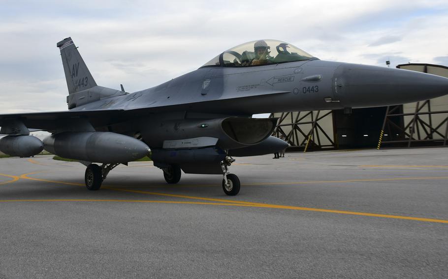 Lt. Col. Benjamin Freeborn, forward deployed commander of the 510th Fighter Squadron, the "Buzzards", shows the Buzzard's claws to loved ones awaiting the arrival of the squadron at Aviano's airfield.