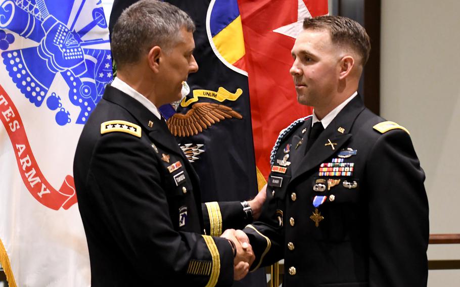 Gen. Stephen J. Townsend, commanding general of the U.S. Army Training and Doctrine Command, congratulates Maj. Nicholas Eslinger, after presenting him with the Distinguished Service Cross during an award ceremony at the Lewis and Clark Center, Fort Leavenworth, Kan., May 3, 2019.