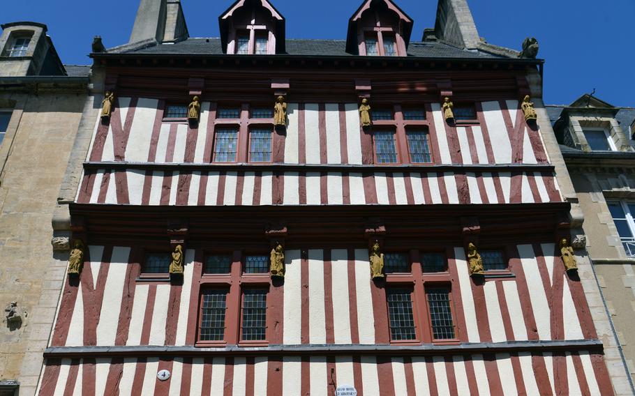 One of the old half-timbered houses in Bayeux historic city center. Note the carved figures adorning the house.