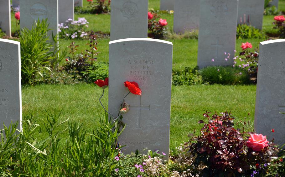 A pair of poppies lean against the gravestone of an unknown soldier at Bayeux War Cemetery. It is the largest Commonwealth cemetery in Normandy, with 4,848 soldiers from the United Kingdom and other countries buried here.