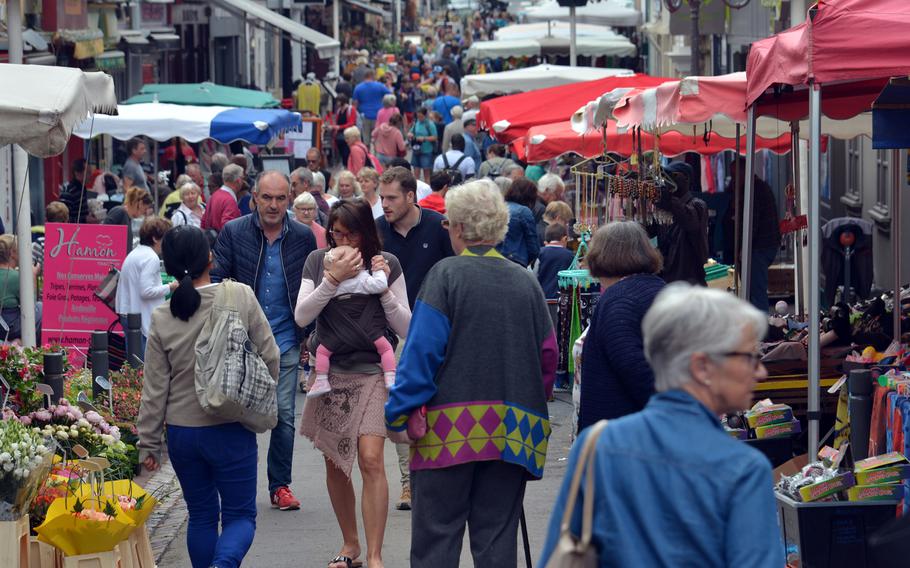 Tourists and locals stroll down Bayeux's Rue Saint Jean during its Wednesday morning market.