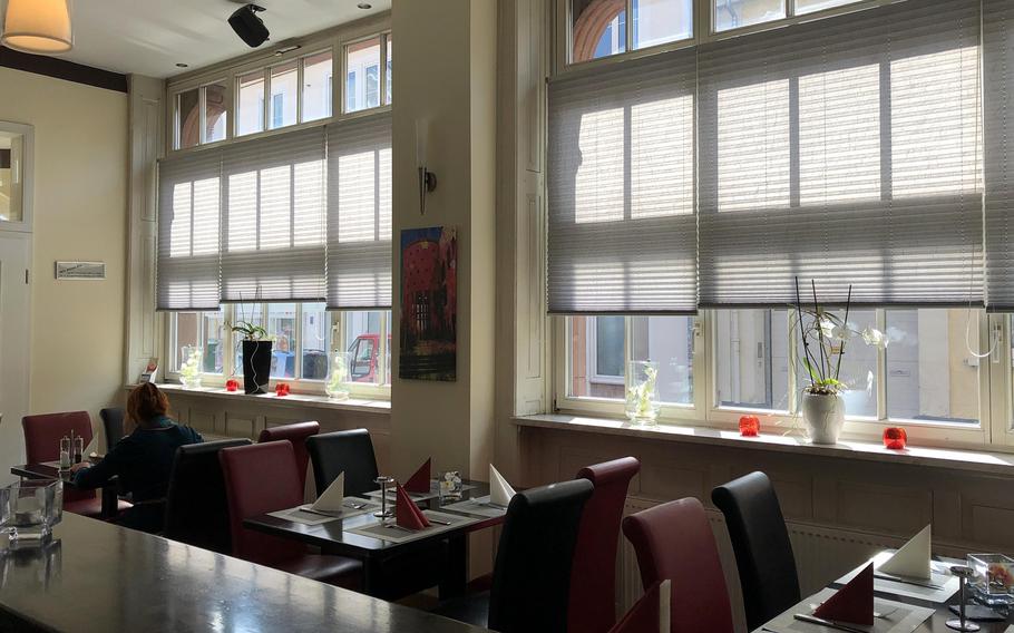 Inside Bistrorante Da Adriana in Kaiserslautern, Germany. It is decorated with modern art-style paintings of the city.