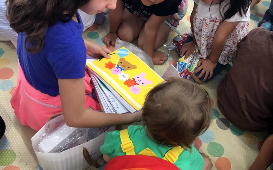 This undated photo shows children at Hoikuen Milk day care in the town of Ishinomaki, Japan, receiving book donations from military families involved in the Helping Hands for Tohoku charity.